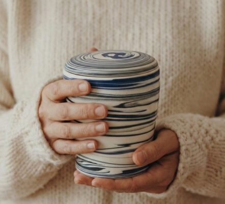 hands holding urn cremation urn
